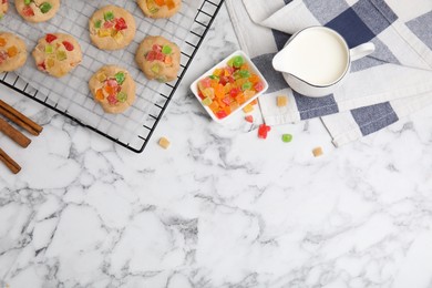Unbaked cookies with candied fruits on white marble table, flat lay. Space for text