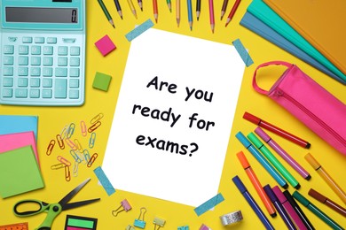 Paper with phrase Are You Ready For Exams and stationery on yellow background, flat lay