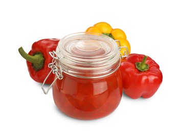 Glass jar of delicious canned lecho and fresh bell peppers on white background