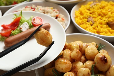 Photo of Taking roasted potato from buffet table, closeup