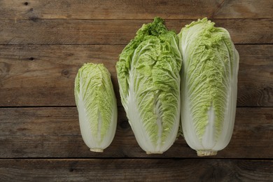 Photo of Fresh ripe Chinese cabbages on wooden table, fat lay