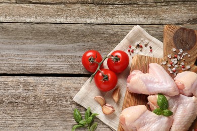 Photo of Raw chicken wings and ingredients on wooden table, flat lay. Space for text