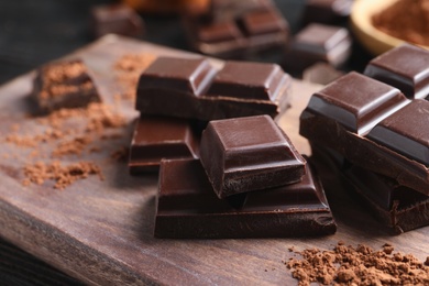 Pieces of black chocolate on wooden board