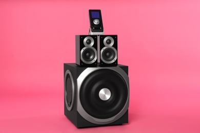 Modern powerful audio speaker system with remote on pink background