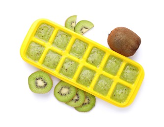 Kiwi puree in ice cube tray and fresh kiwi fruits isolated on white, top view. Ready for freezing