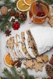 Traditional Christmas Stollen with icing sugar on white table, flat lay