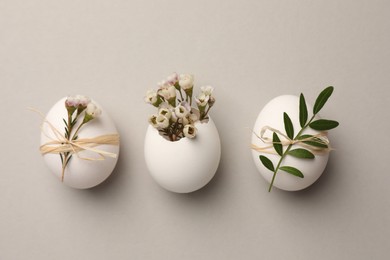 Photo of Festive composition with chicken eggs and natural decor on light grey background, flat lay. Happy Easter