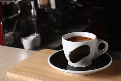 Cup of fresh aromatic espresso on wooden table in cafe, space for text