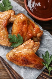 Photo of Delicious fried chicken wings on wooden table, top view