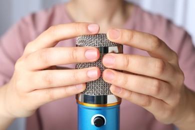 Woman making ASMR sounds with microphone, closeup