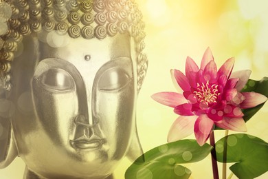 Beautiful golden Buddha sculpture and lotus flower on color background