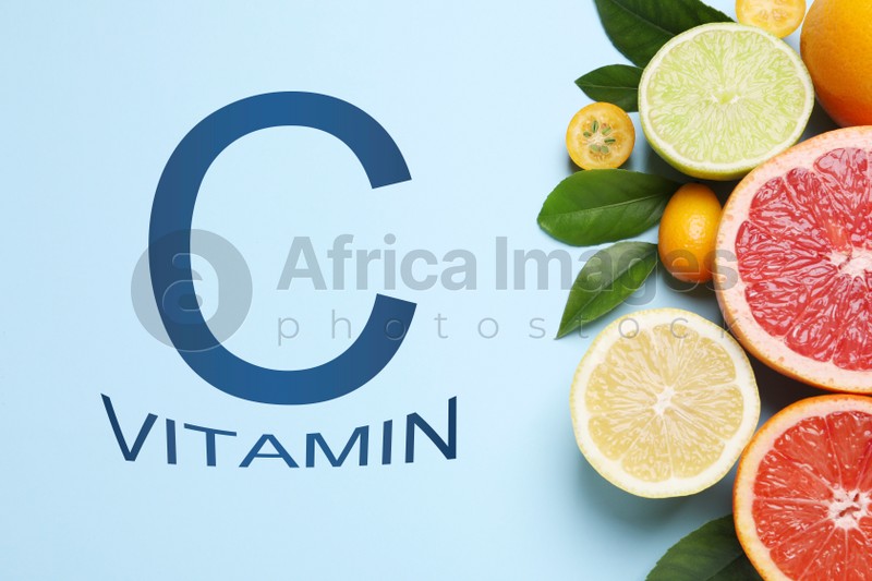 Source of Vitamin C. Fresh juicy citrus fruits with green leaves on light blue background, flat lay