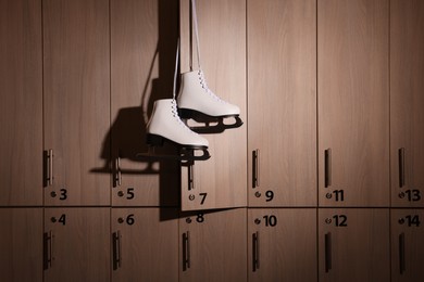 Ice skater boots hanging on locker door in changing room