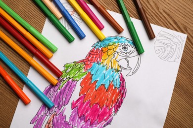 Child's colored drawing with felt tip pens on wooden table, flat lay
