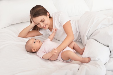 Portrait of mother with her cute baby lying on bed