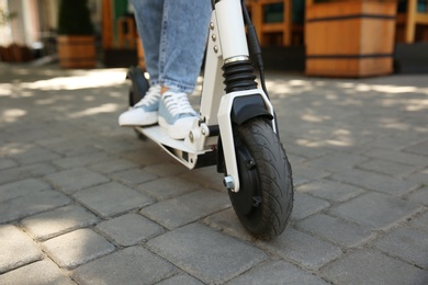 Woman riding electric kick scooter outdoors, closeup