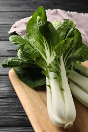 Fresh green pak choy cabbages on black wooden table, closeup