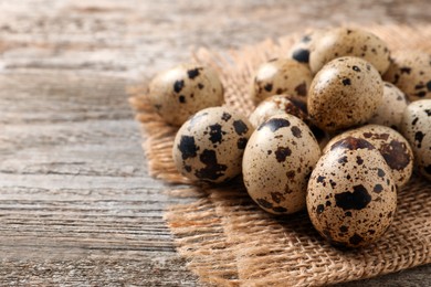 Photo of Fresh quail eggs on wooden table. Space for text