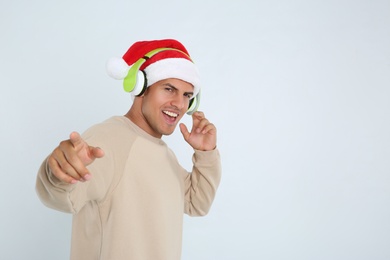 Emotional man with headphones on white background, space for text. Christmas music