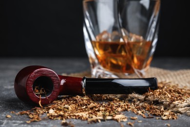 Smoking pipe with tobacco on grey table