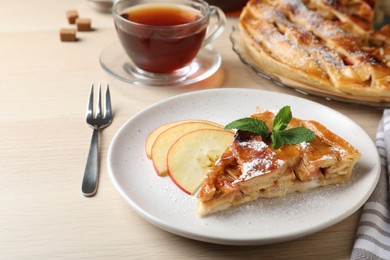 Photo of Slice of traditional apple pie served on wooden table