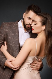 Handsome bearded man with sexy lady on grey background