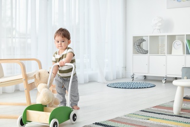 Photo of Cute baby learning to walk and playing at home
