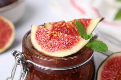 Photo of Tasty sweet fig jam and fruits on table, closeup