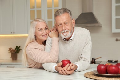 Happy senior couple at table in kitchen