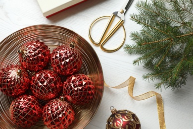 Flat lay composition with beautiful Christmas baubles on white wooden table