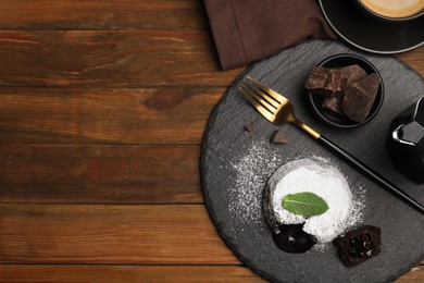 Delicious fresh fondant with hot chocolate and mint on wooden table, flat lay. Space for text