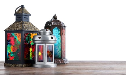 Decorative Arabic lanterns on wooden table against white background