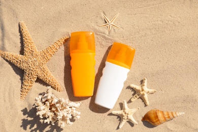 Flat lay composition with bottles of sunblock on sandy beach