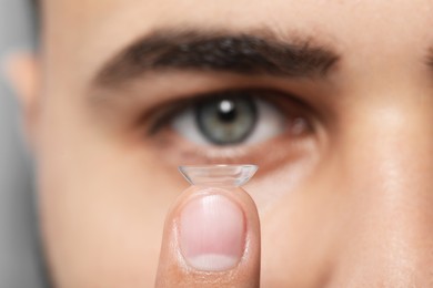 Young man with contact lens, focus on finger