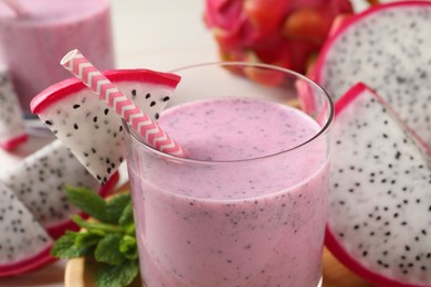Delicious pitahaya smoothie and fresh fruits on table, closeup