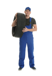 Full length portrait of professional auto mechanic with tire on white background