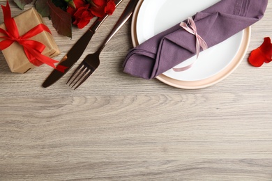 Beautiful place setting on wooden table, flat lay with space for text. Valentine's day romantic dinner