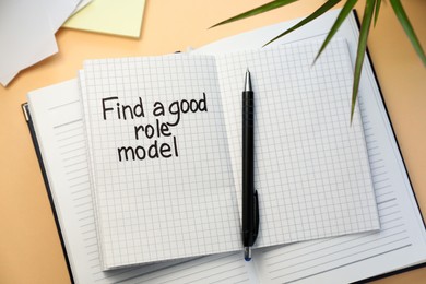 Notebook with phrase Find A Good Role Model and pen on beige background, flat lay