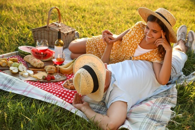 Happy couple having picnic in park on sunny day