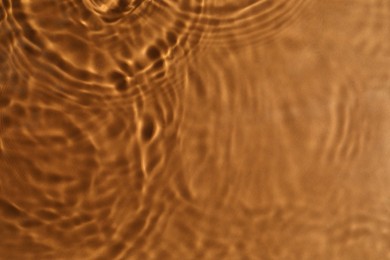 Closeup view of water with circles on brown background