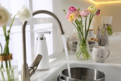 Light kitchen decorated with beautiful fresh ranunculus flowers