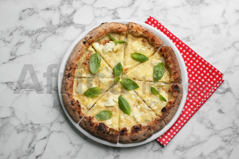 Photo of Tasty cheese pizza with basil on white marble table, top view