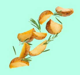 Tasty baked potatoes and rosemary falling on cyan background
