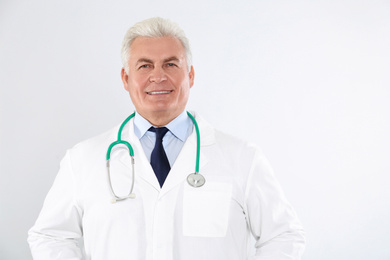 Portrait of senior doctor with stethoscope on white background