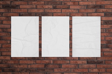 Blank creased posters on brick wall. Mockup for design 