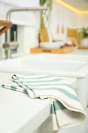 Clean towel near white sink in kitchen