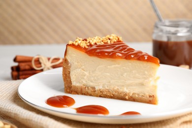 Photo of Tasty cheesecake with caramel and nuts served on table, closeup