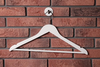 White clothes hanger on red brick wall