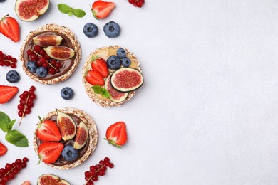 Flat lay composition with tasty crispbreads and berries on light table. Space for text