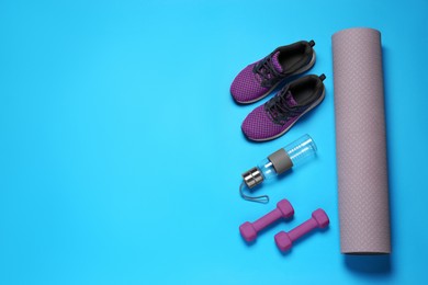 Exercise mat, dumbbells, bottle of water and shoes on turquoise background, flat lay. Space for text
